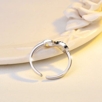 Silver infinity ring by Fuchsia Molly adorned with sparkling rhinestones, showcasing a sleek and elegant design.