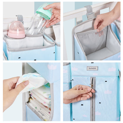Maroon Chronos baby crib organizer in nursery with multiple compartments for baby essentials, hanging on a crib rail.