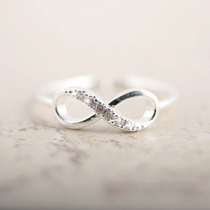 Silver infinity ring with rhinestones by Fuchsia Molly, showcasing a sparkling, elegant design in a close-up shot.