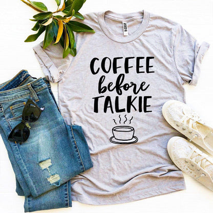 Agate Coffee Before Talkie T-shirt showing a casual white cotton T-shirt with black printed text, laid flat on a neutral background.