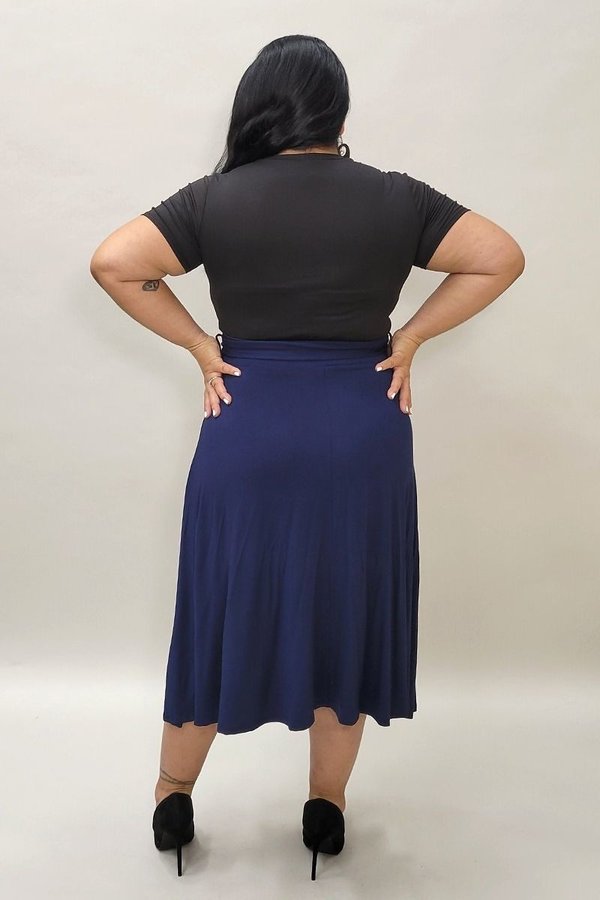 Solid high waist midi skirt with waist tie from Burgundy Daisy, modeled on a woman showing the flowy design and stylish fit.