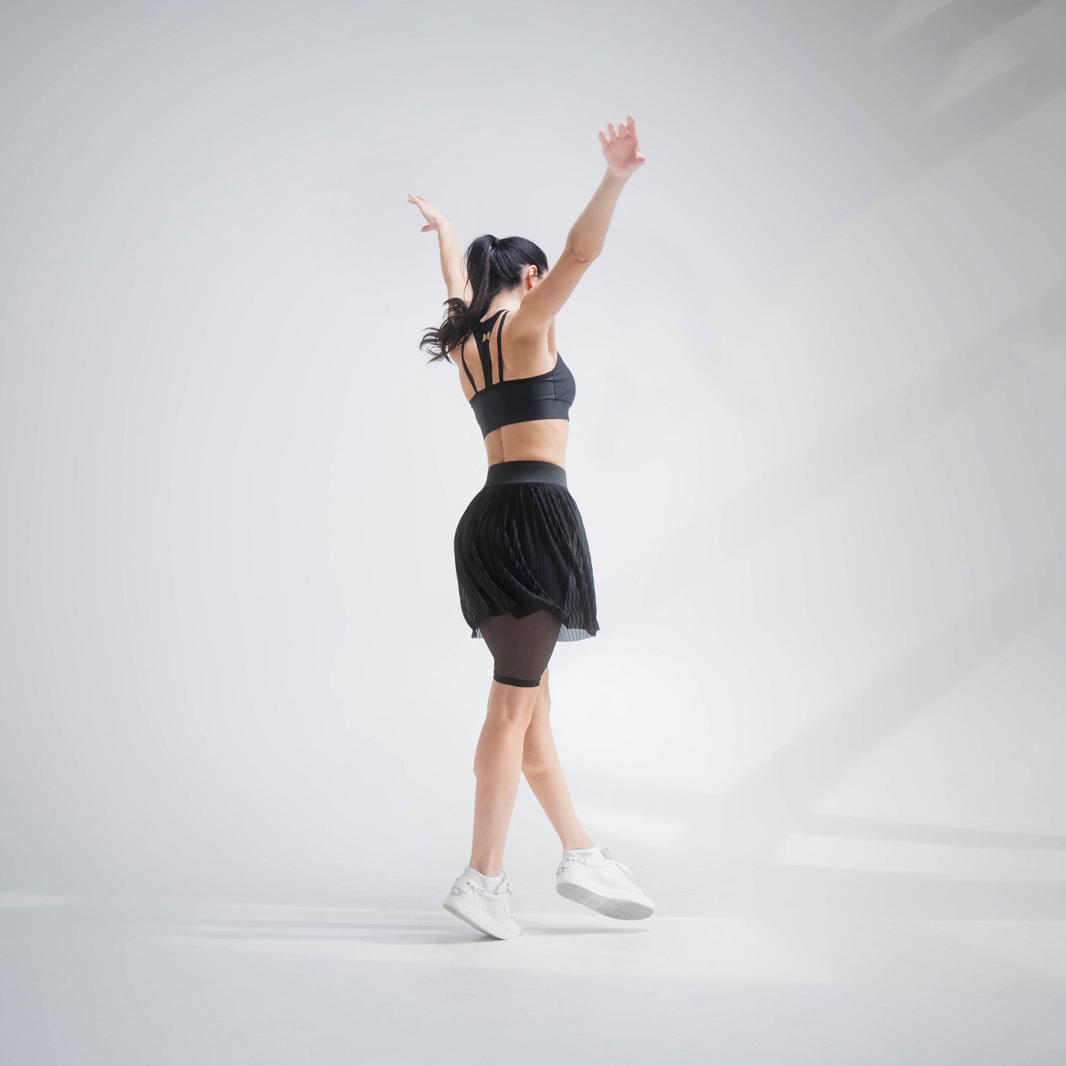 Indigo Thalassa MINI PLESSY MESH SKIRT showing a lightweight, black mesh skirt with pleated design and elastic waistband.