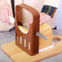 Fuchsia Molly bread slicer for home use, featuring a wooden base with adjustable slicing guides and a serrated bread knife.