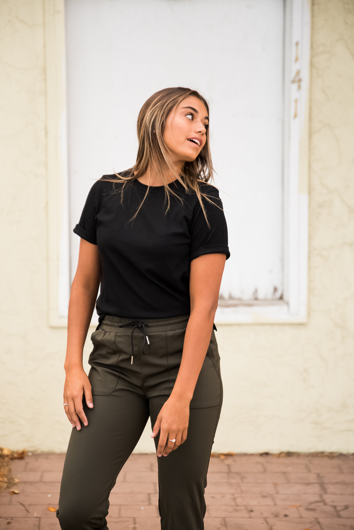 Black DT Alyssa Rib Knit Split Hem Tee by Lavender Danae, showcasing fitted ribbed fabric and stylish split hem detail.
