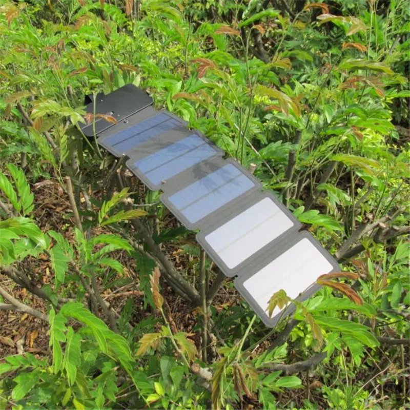 Fuchsia Molly folding solar charger for camping, with multiple solar panels and adjustable stand in outdoor setting