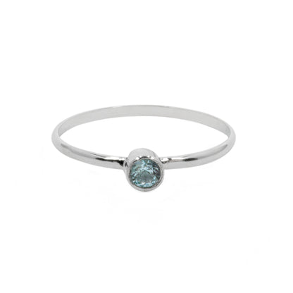 Sterling silver ring with dainty blue topaz solitaire gemstone, elegant jewelry piece by Grey Clymene.