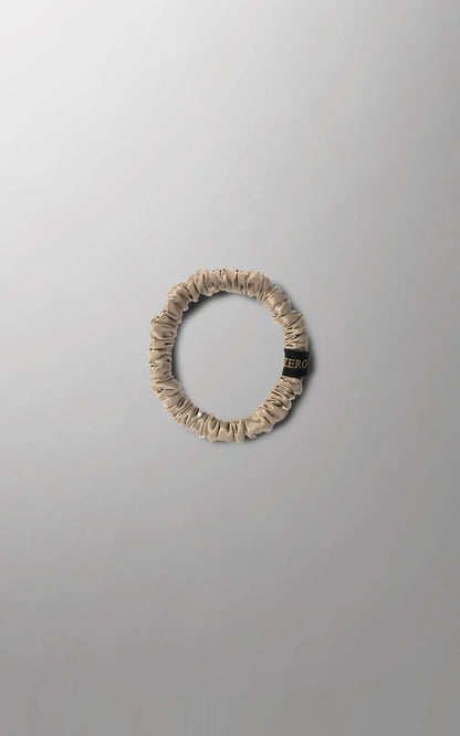 Silk hair ties in gray, golden, and white from Burgundy Clover, available in medium and large sizes, shown in close-up.