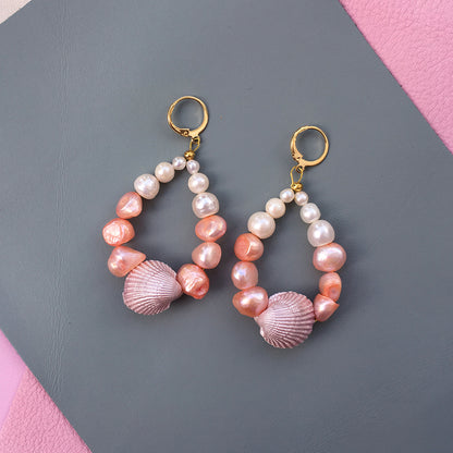 Yellow Athena Candy Shell Pearl Earrings featuring round pearl dangles on gold hooks, stylish and elegant jewelry accessory.