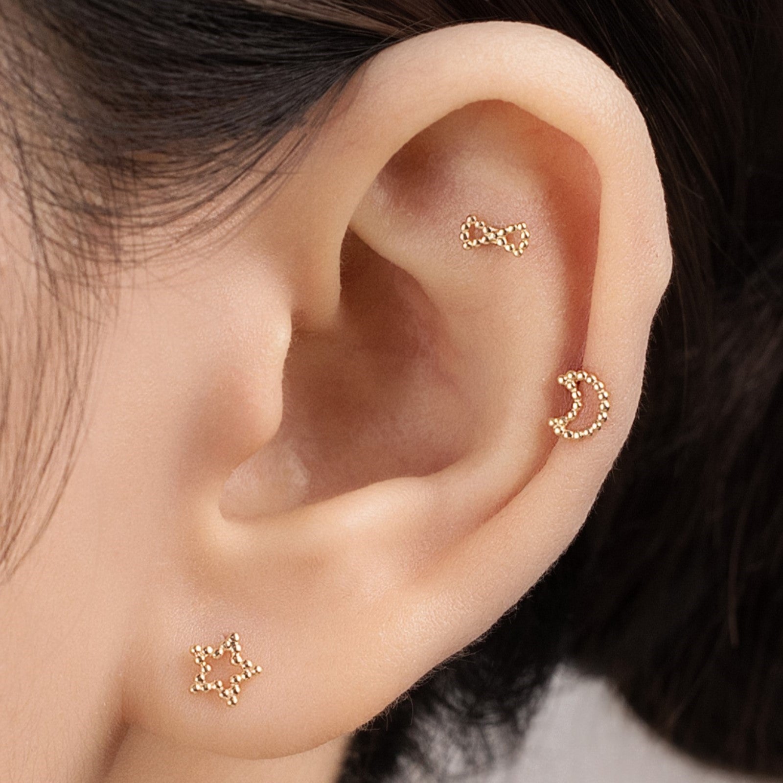 Blue Chrysippus 14K solid gold Stella piercing earrings with a star design, shiny and detailed in a close-up image.