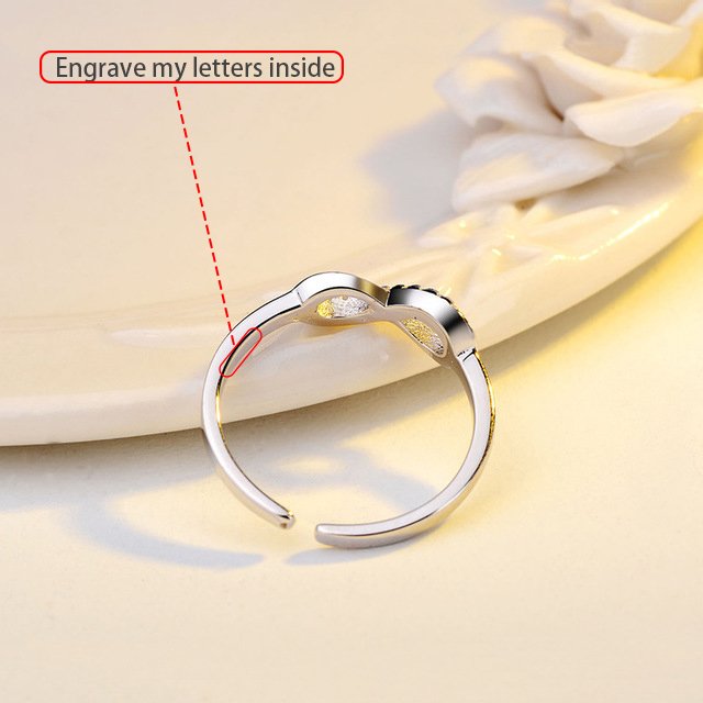 Silver infinity ring with rhinestone accents by Fuchsia Molly, showcasing a sleek and sparkling design in close-up view.