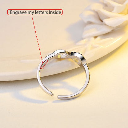 Silver infinity ring with rhinestone accents by Fuchsia Molly, showcasing a sleek and sparkling design in close-up view.