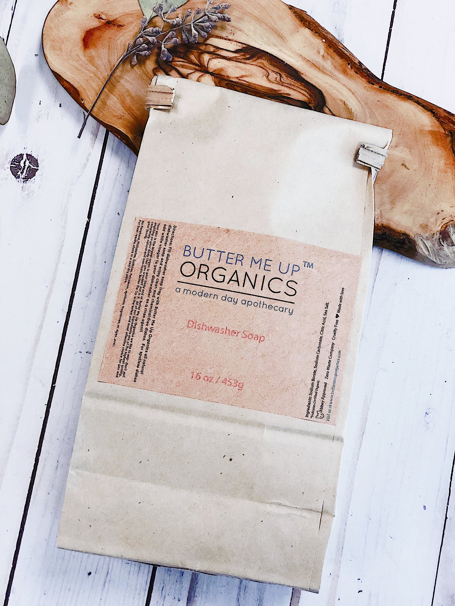White Smokey all natural dishwasher soap in a kitchen setting, showing the eco-friendly detergent container.