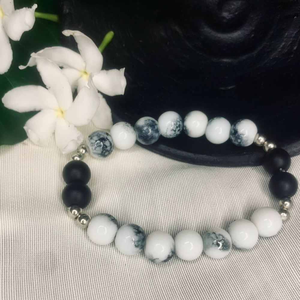 Howlite and black onyx stretch bracelet with silver spacers, featuring smooth white and black beads, by Tan Saffron.