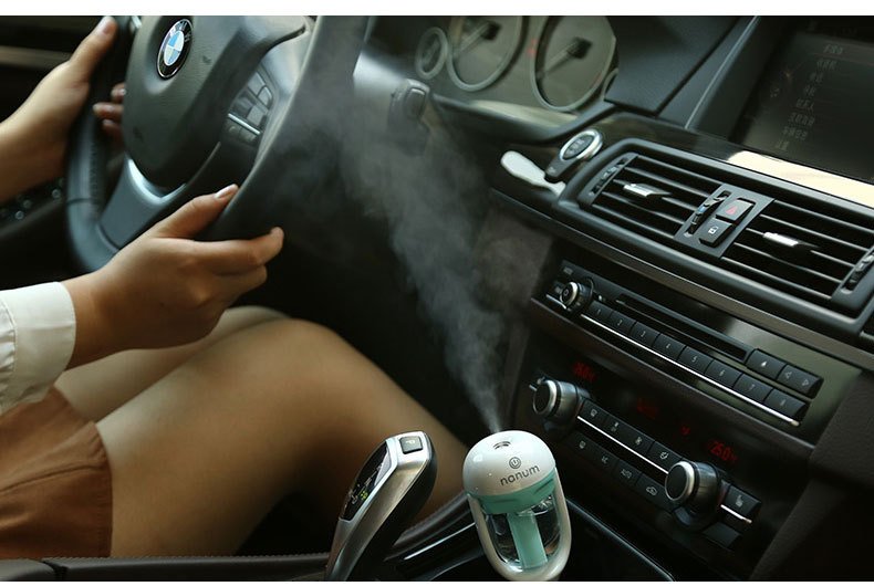 Fuchsia Molly Nanum automotive car humidifier in a sleek design, placed inside a vehicle for freshening the air.