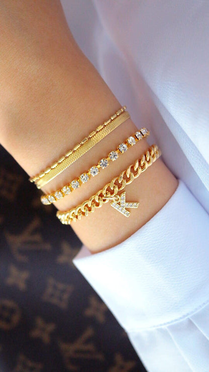 Gold custom initial 24K thick Cuban chain bracelet by Ultramarine Birch featuring bold, shiny links and a personalized initial pendant.