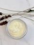 White Smokey organic face cream facial moisturizer in a white jar with a silver lid, showing smooth cream inside.