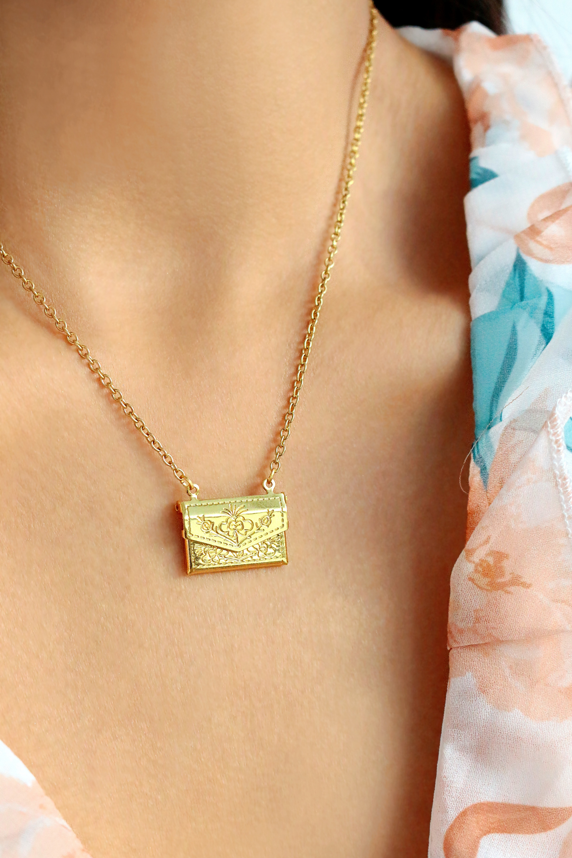 Ultramarine Birch 24 Karats Daisy Envelope Locket Necklace featuring a delicate daisy design and gold finish on a chain.
