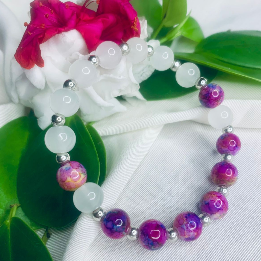 White and purple stone bracelet with silver spacers from Tan Saffron, stretch style featuring polished stones and shiny silver accents.