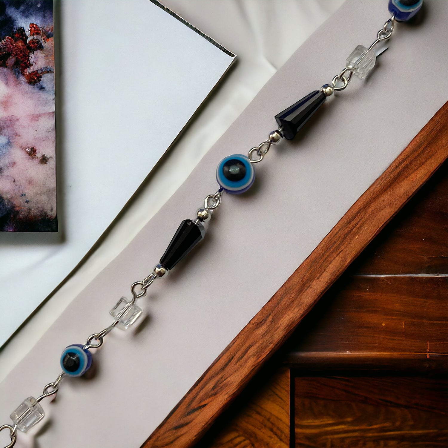 Gray Poseidon Fortune’s Shield Evil Eye bracelet featuring blue and silver beads on a stretchy jewelry band.