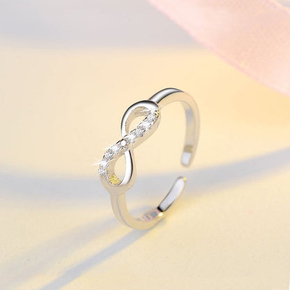 Silver infinity ring with rhinestone accents from Fuchsia Molly, showcasing the detailed design and sparkling embellishments.