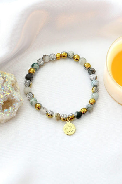 Mossy agate elastic bracelet with 24K gold lotus flower charm, featuring natural stone beads and a stylish, handcrafted design.
