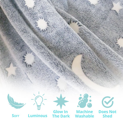 Gray and blue glow-in-the-dark blanket and pillow set by Plum Aion, featuring soft fabric and luminous accents in a cozy bedroom setting.