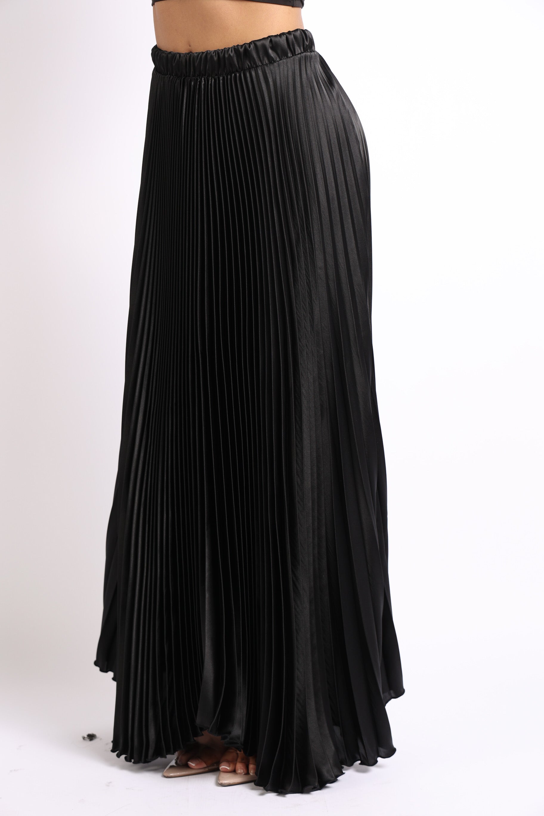 Black satin maxi skirt by Puce Juniper featuring an elastic high waist and A-line pleated design.