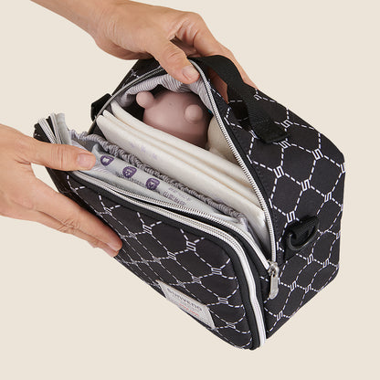 Maroon Chronos all-in-one diaper bag with changing pad, black fabric with multiple compartments for parent and baby essentials.
