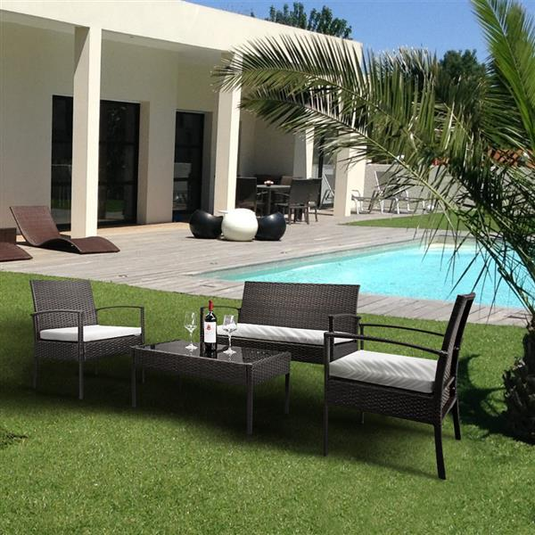 Set of four rattan patio furniture pieces by Lilac Milo, including chairs and a table, for outdoor lounging and dining.