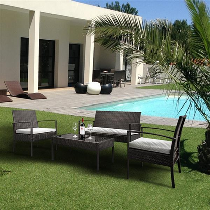 Set of four rattan patio furniture pieces by Lilac Milo, including chairs and a table, for outdoor lounging and dining.