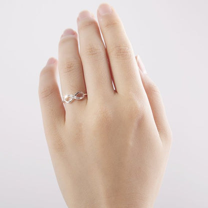 Silver infinity ring with rhinestone accents by Fuchsia Molly, showcasing a sleek, elegant design on a white background.