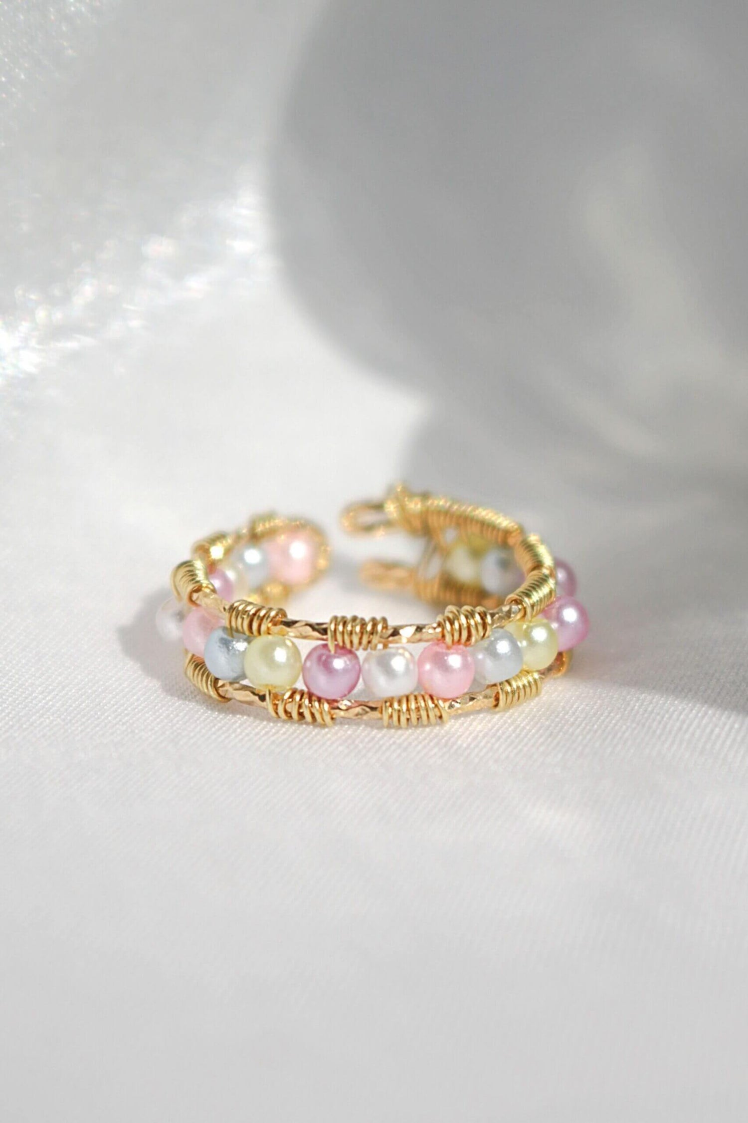 18K pastel rainbow hand-wired band ring by Ultramarine Birch, featuring colorful pastel gemstones and intricate wire detailing.