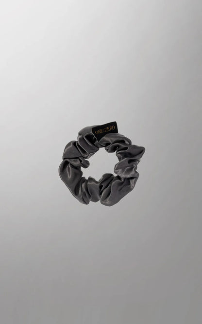 Silk hair ties by Burgundy Clover in gray, golden, and white, shown in medium and large sizes, arranged on a white background.