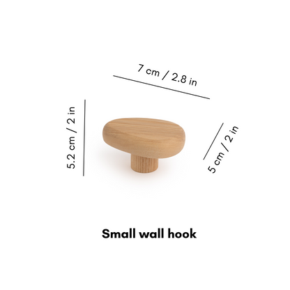 Wooden wall hook DROP by Biotite for organization, shown mounted on a wall with hooks for hanging items.