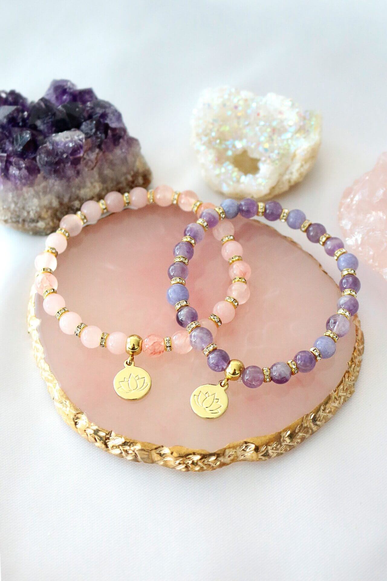 Ultramarine Birch rose quartz and amethyst elastic bracelet with a 24K lotus flower charm on a white background.