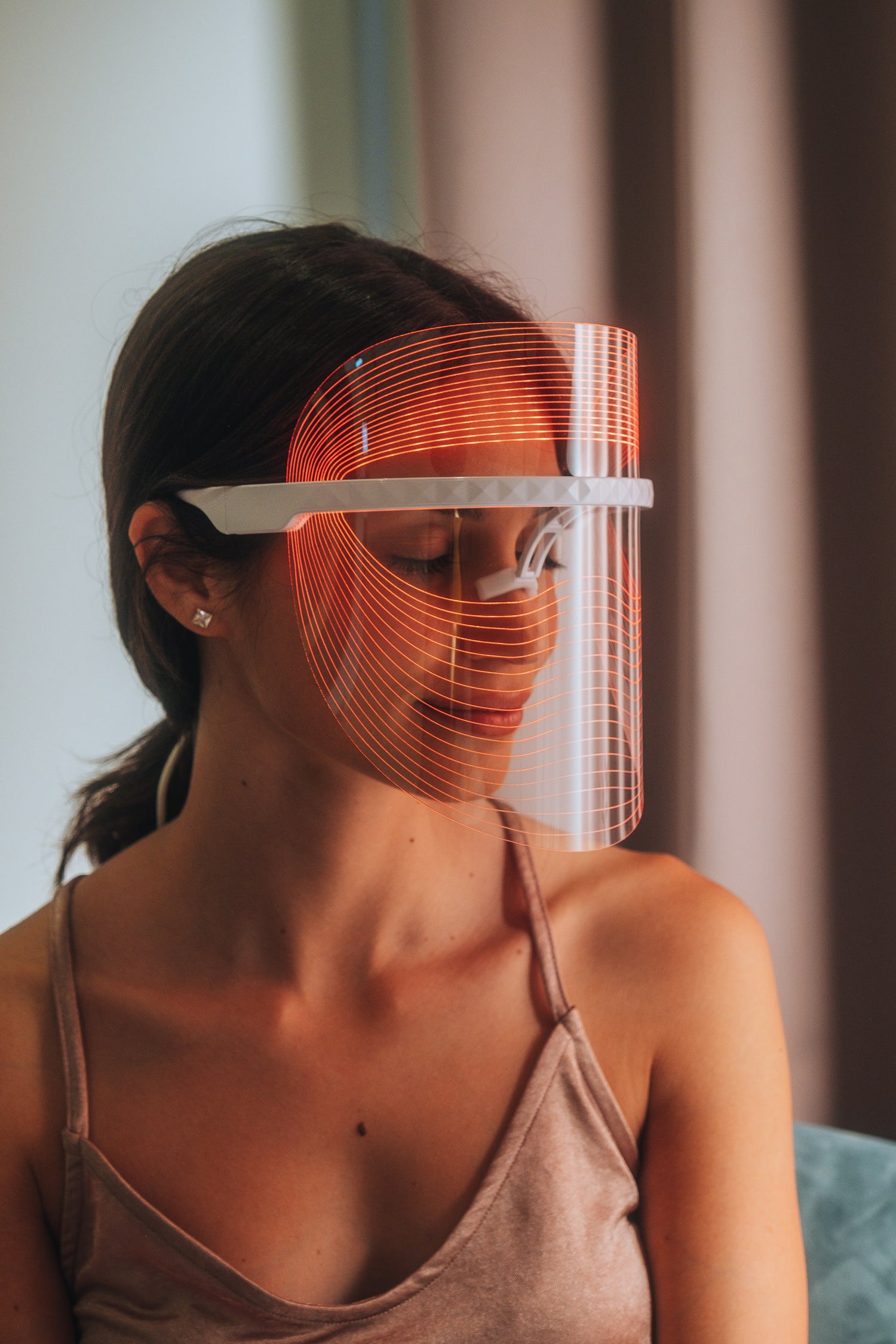 Scarlet Chrysippus Cocoon Skin Enlightenment LED Face Mask showing a sleek black facial mask with built-in LED lights for skincare.