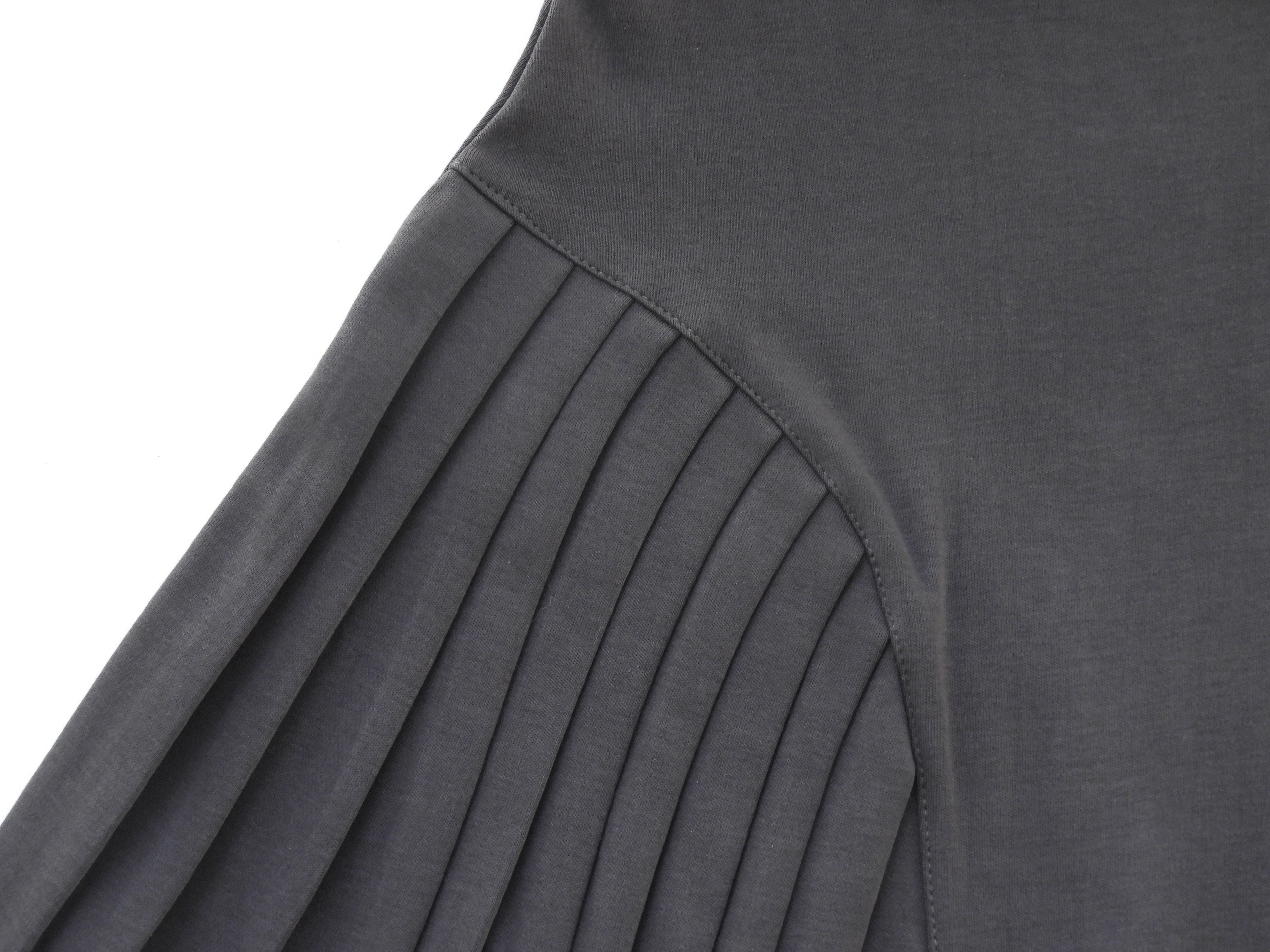 Emerald Hephaestus half-pleated mini skirt in black, shown on a model with a fitted waist and stylish design.