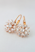 Diamond Sunflower Huggies earrings by Ultramarine Birch, 18K gold plated with sunflower and diamond details, close-up view.