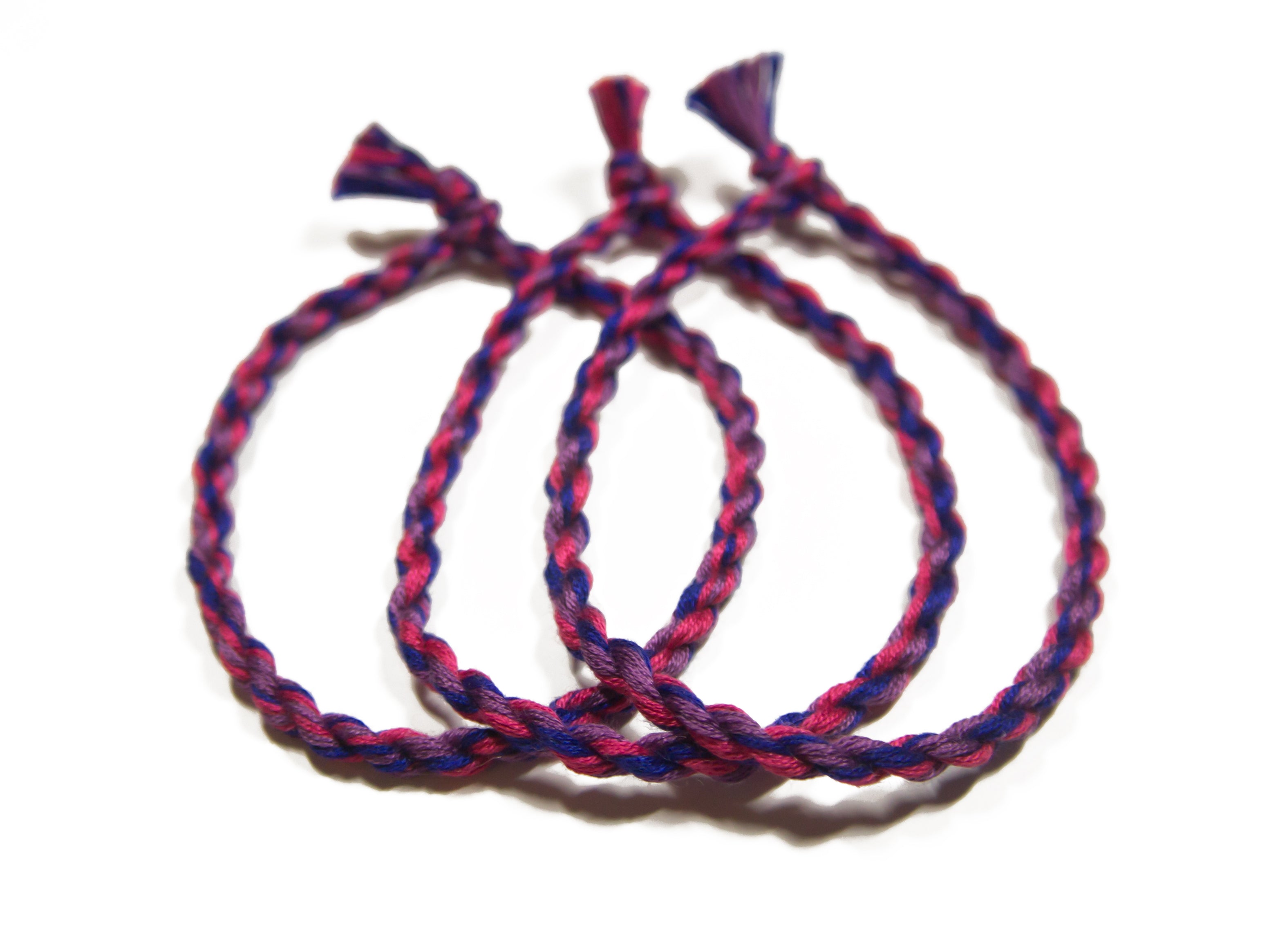 Handmade bisexual friendship bracelet by Rose Erebus featuring colorful cotton strands representing LGBTQ pride.