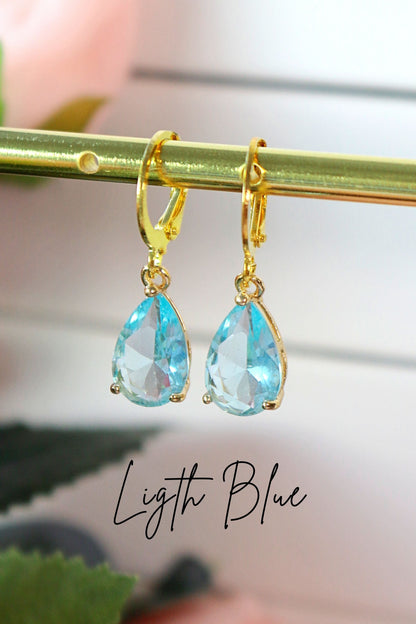 Ultramarine Birch 18K rainbow teardrop hoop earrings with colorful gemstone accents hanging from gold hoops.