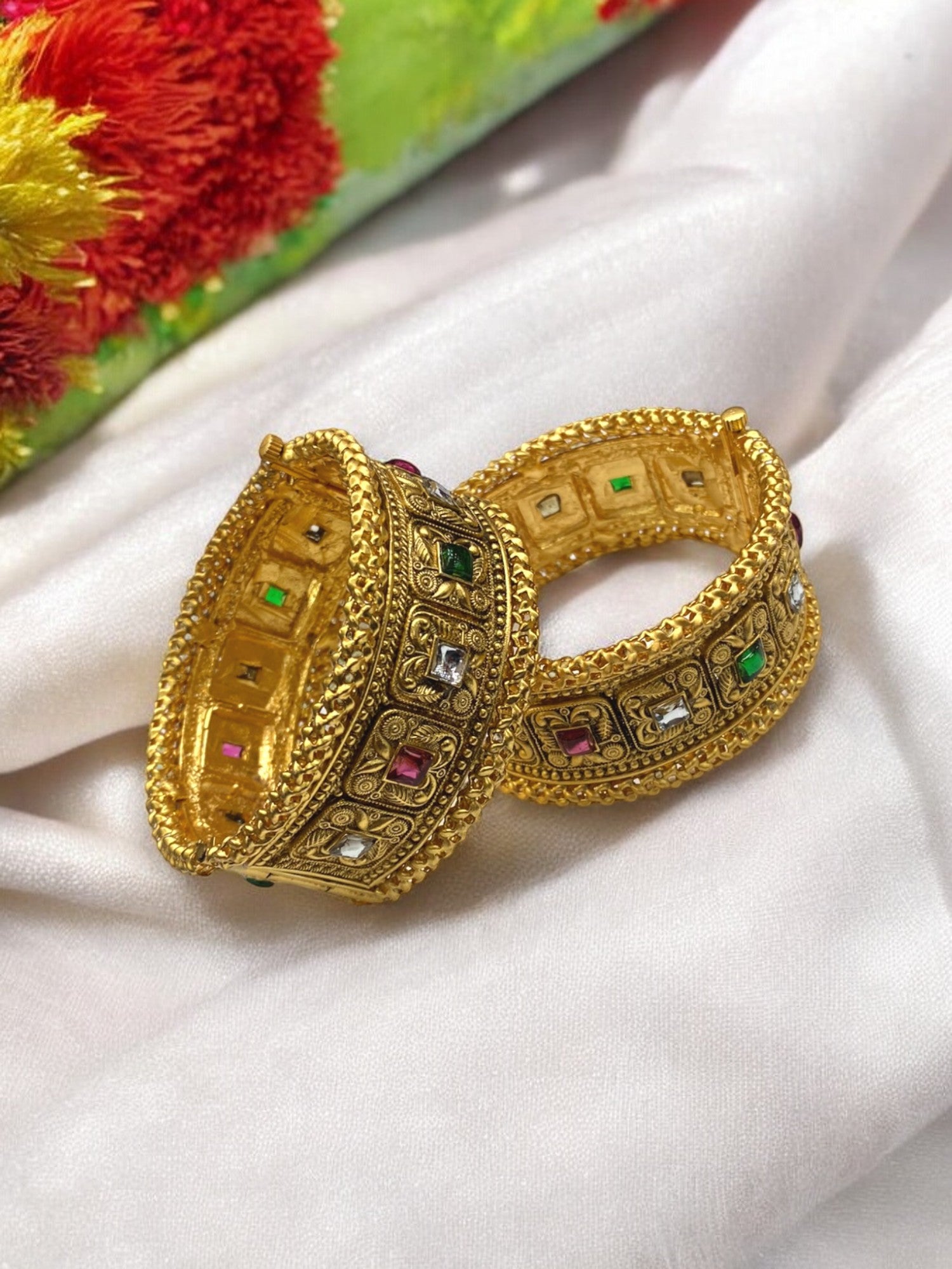 Gold-plated Indian bangles from Gray Poseidon featuring intricate traditional designs with a modern touch, displayed in a close-up shot.