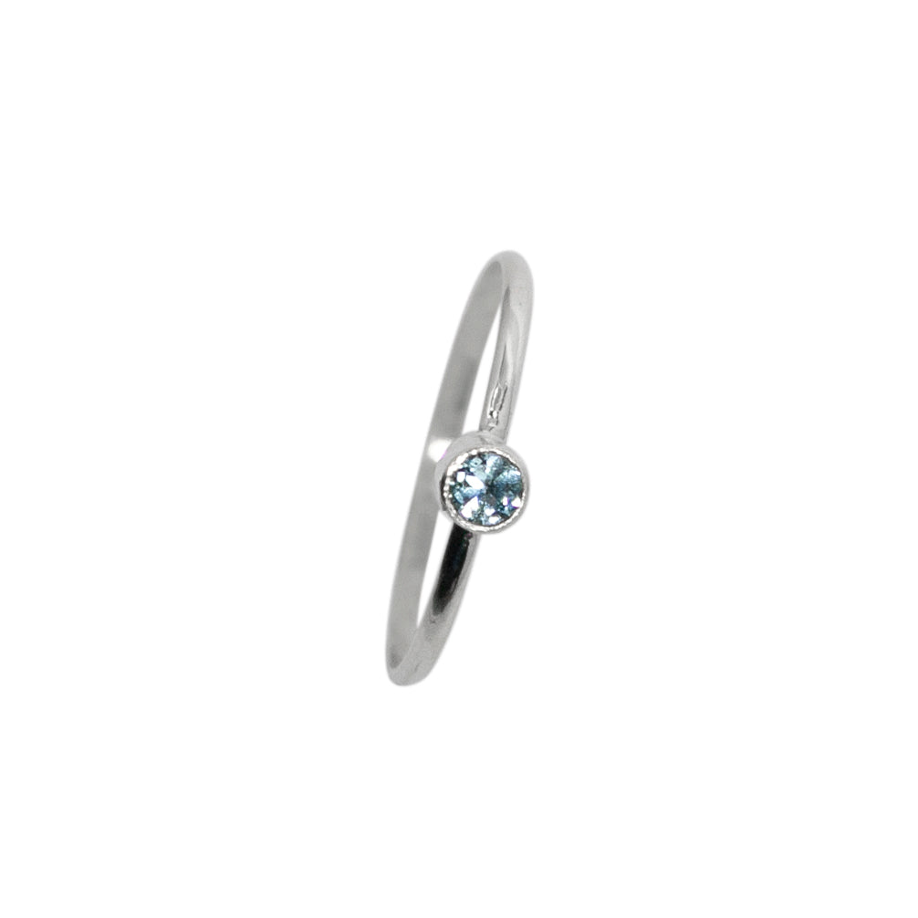 Sterling silver ring with a dainty blue topaz solitaire gemstone from Grey Clymene, featuring a sleek tube design.