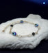 Gray Poseidon Fortune’s Shield Evil Eye bracelet featuring a protective blue eye charm on a silver-tone jewelry bracelet.