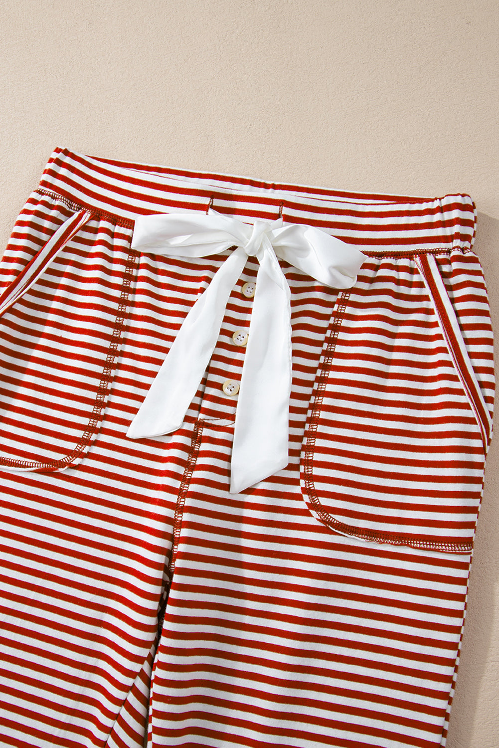 Byzantium Bay Christmas stripe lounge set with a long-sleeve top and matching pants, featuring red, green, and white holiday patterns.
