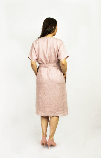Pale pink linen wrap dress by Magenta Sugarplum, featuring a flattering silhouette and soft fabric for a stylish, comfortable look.