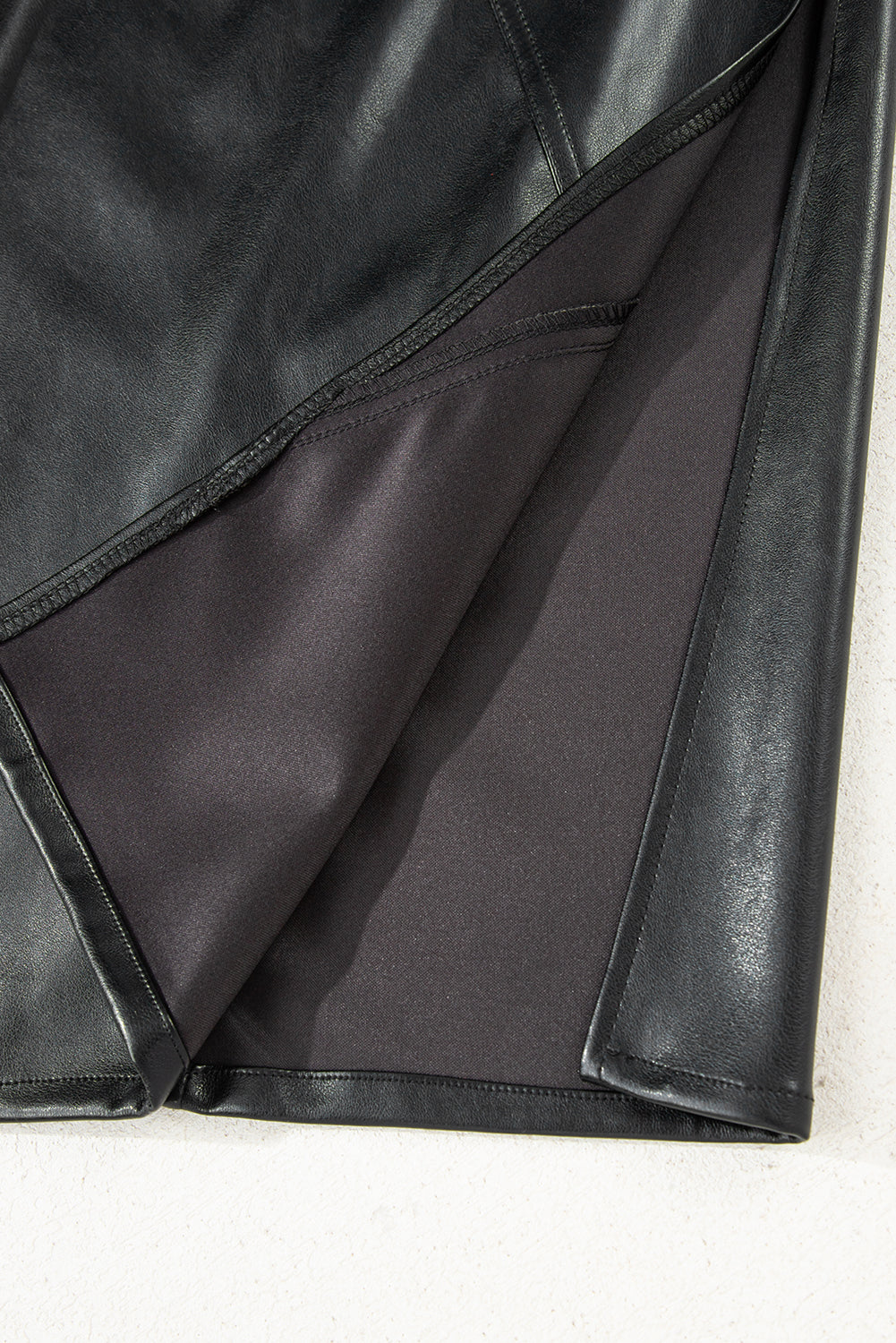 Black solid faux leather side slit maxi skirt for women by Byzantium Bay, featuring a flowing silhouette and stylish side slit.