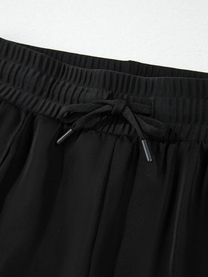 Pear Daisy high waisted drawstring swim shorts shown on a model, ideal for beach or poolside wear in a stylish design.