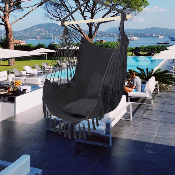 Gray LuneluX boho hanging chair with fringe and cushions by Carmine Juneberry, showcasing a cozy, stylish furniture piece.