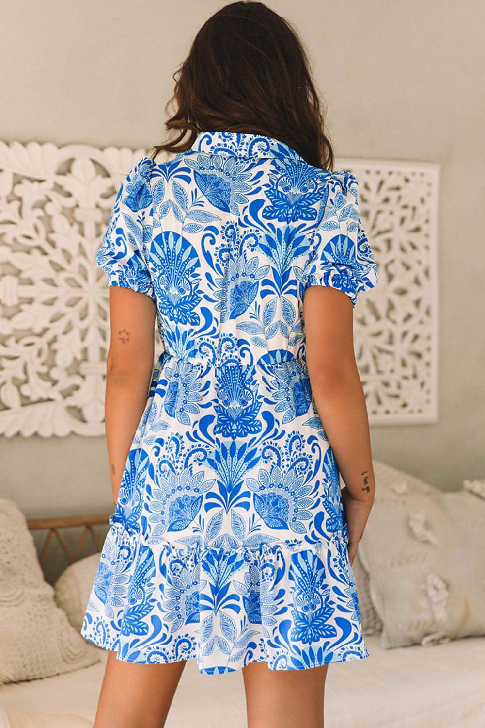Sky blue retro floral print mini dress by Carmine Juneberry featuring ruffled details and a drawstring waist.