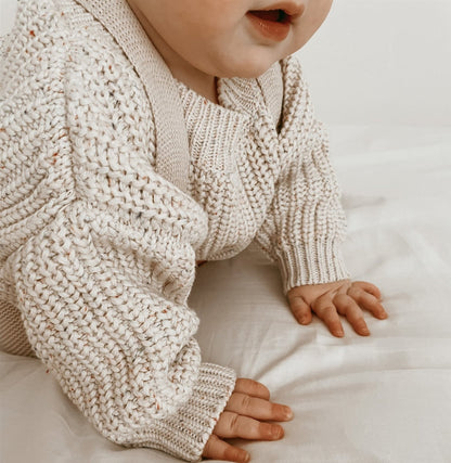 Carmine Juneberry SnuggleThread™ cotton knit baby sweater in soft pastel pink, featuring long sleeves and cozy knit texture.